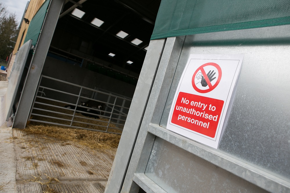 A no entry sign on the door of a cattle barn