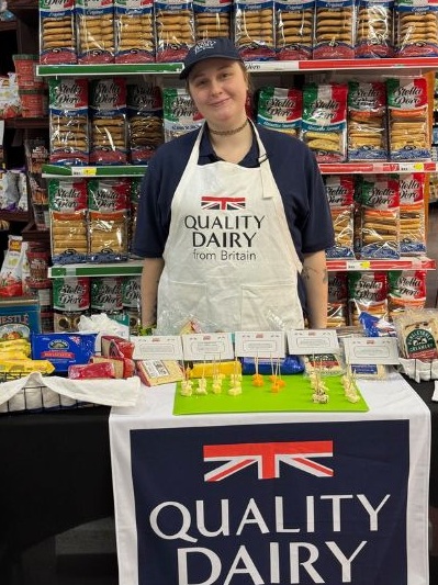 A woman working on a Quality Dairy stand.
