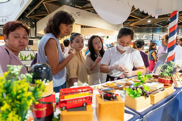 People looking at a cheese-tasting stand.