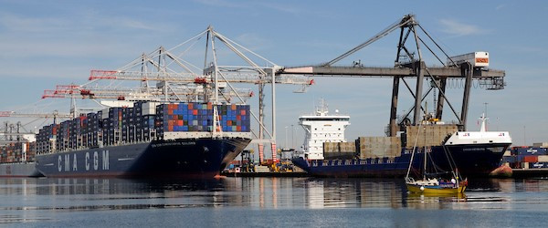 Shipping containers being loaded on to a ship by a crane.