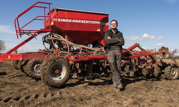 a man standing next to a red tractor