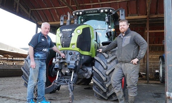 Farmers standing in front of a tractor