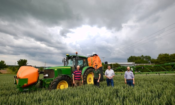 a group of people standing next to a tractor in a field