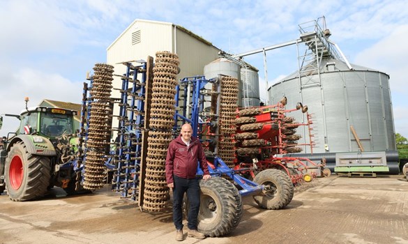 A man standing in front of machinery at Norwich Monitor Farm.