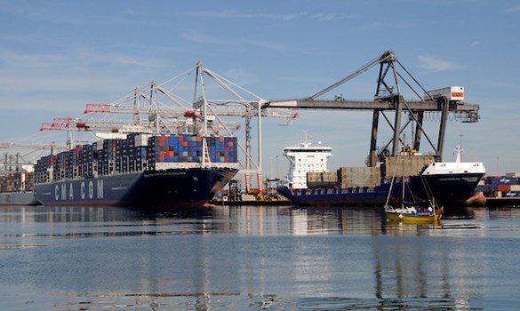 Shipping containers being loaded onto a boat by a crane.