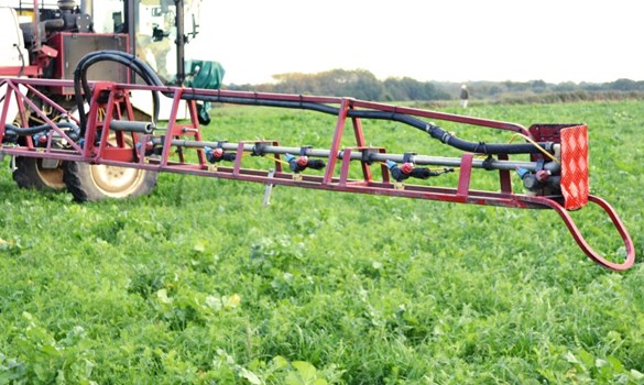 A crop spraying arm with nozzles visible