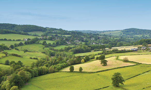 An aerial view of countryside and fields with a blue sky