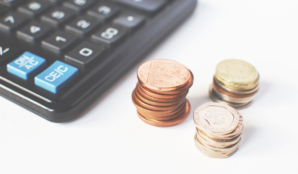 a few coins next to a calculator