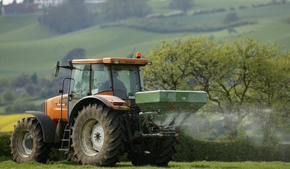 A tractor spreading fertiliser.