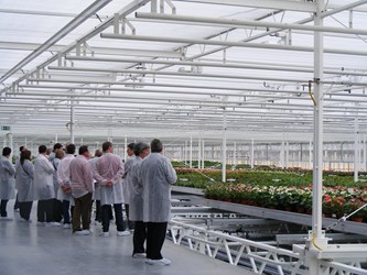 a group of people standing in a greenhouse